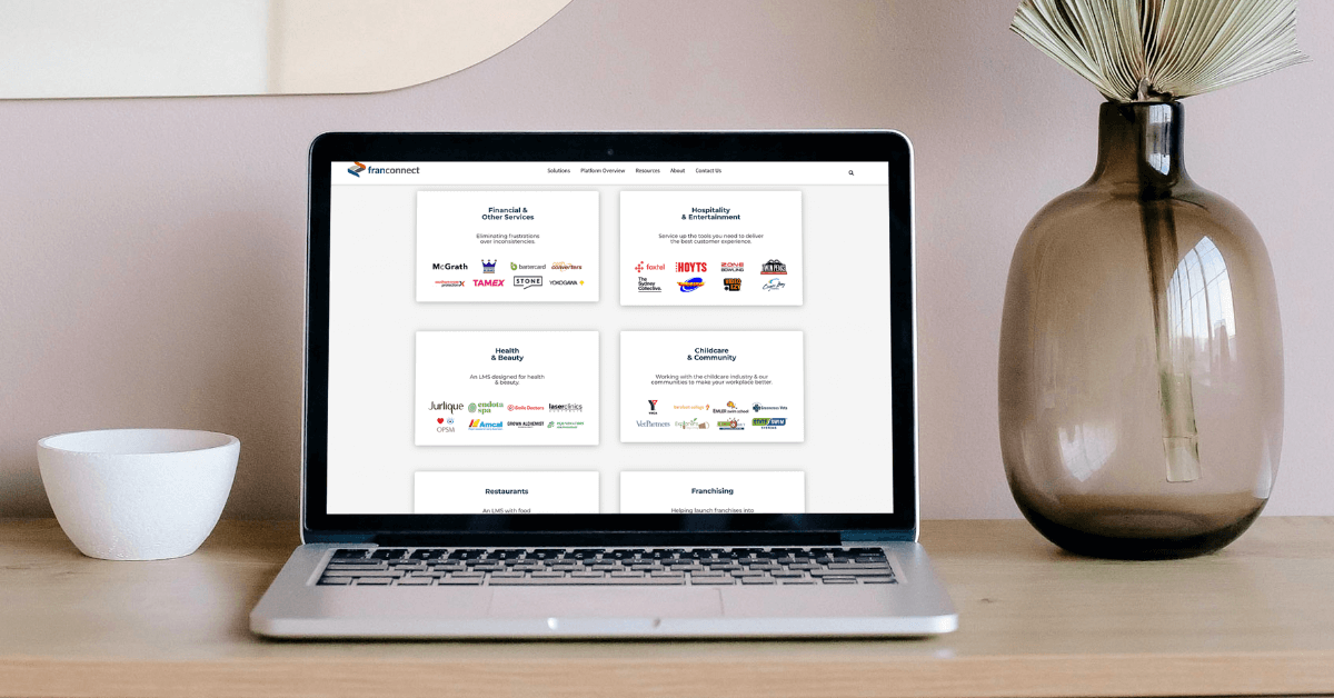 A laptop shows industries we work with for FranConnect's World Manager