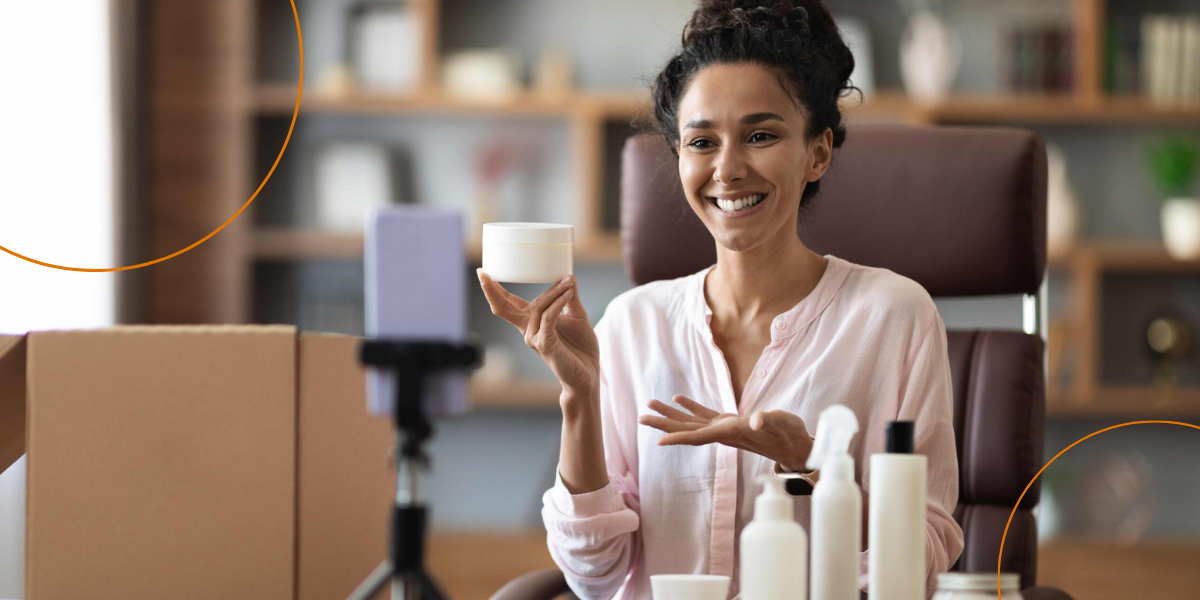 A woman smiles while vlogging about beauty products