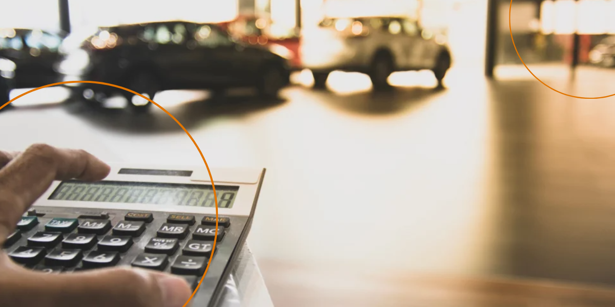 A man uses a calculator in a car dealership