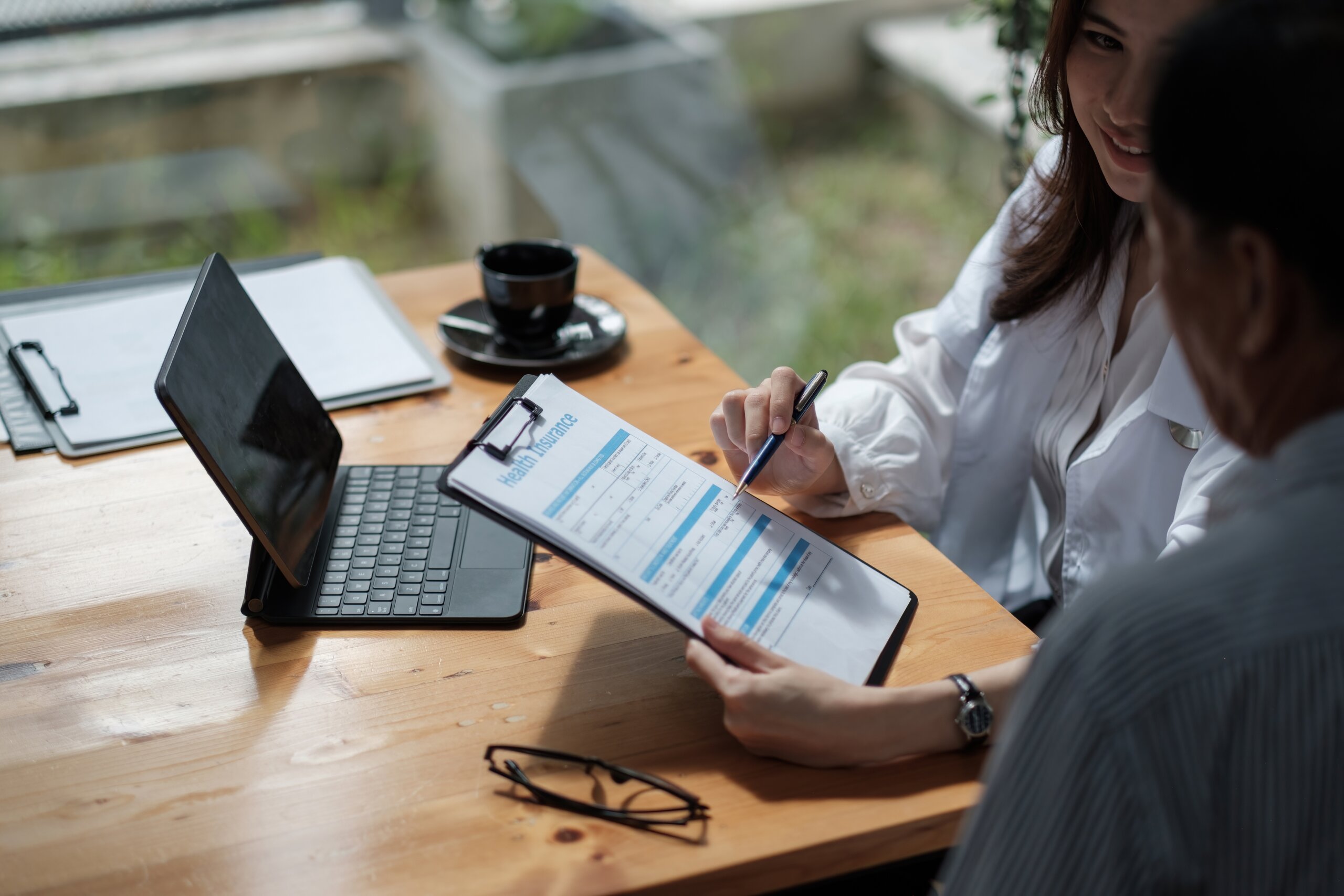 People fill out a health insurance form in an office