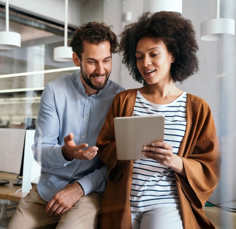 Group,Of,Designers,,Business,People,At,Work,In,Corporate,Office. - FranConnect Franchise development leader reviewing 2025 franchise sales benchmarks on a dashboard