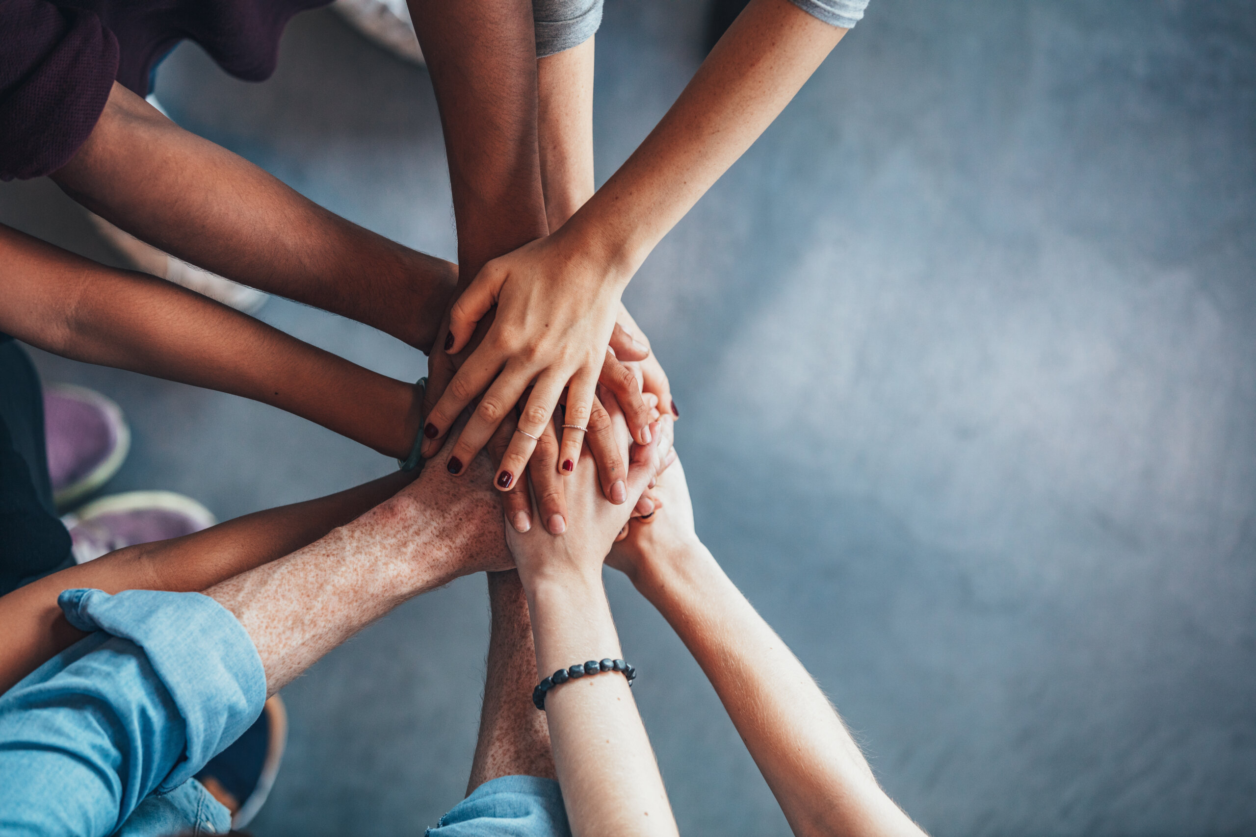 A group of people pile their hands together