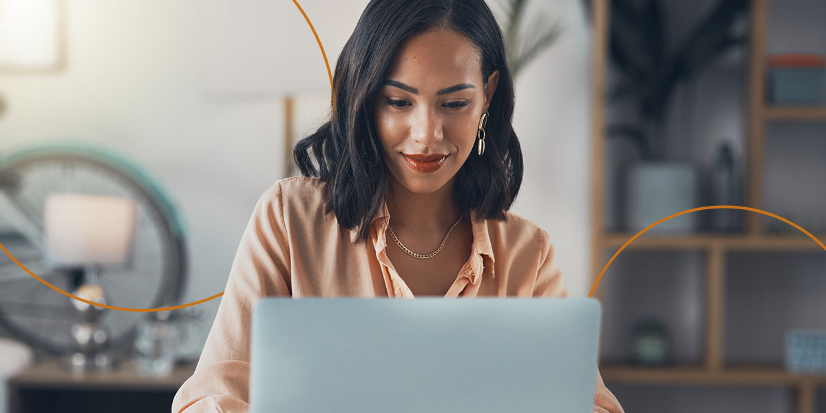 A young woman wearing red lipstick works on a laptop