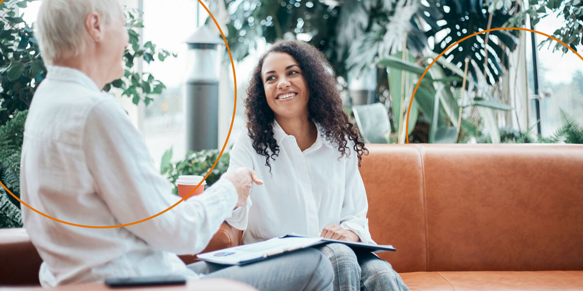 Two women interview with each other over coffee