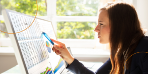 A young businesswoman analyzes a graph closely
