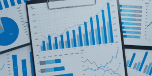 white background with reports in the foreground that are various shades of blue bar graphs